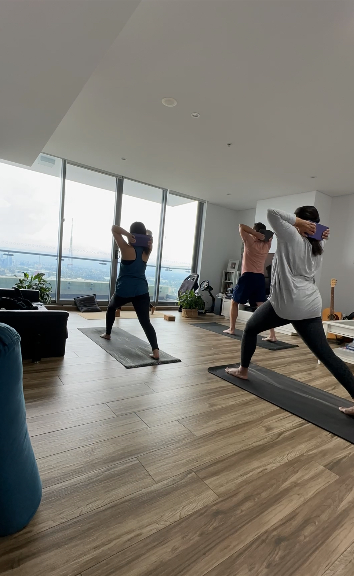 People practising guided breath and movement in a bright room overlooking the city